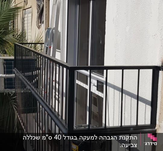 מעקה מתכת שחור על מרפסת עם דלת זכוכית